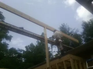 Carpenter setting a ridge beam over a new addition frame — Ice Dam Removal by Roofing Brothers in Eden Prairie