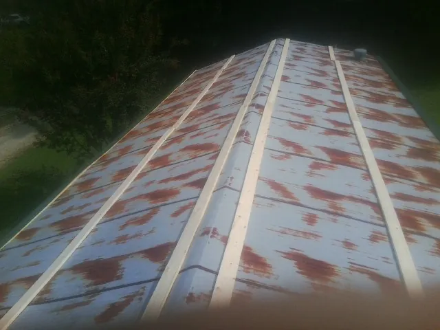 Rusted metal roof panels with new wood purlins before replacement — Storm Damage Roof Repair in Eden Prairie by Roofing Brothers