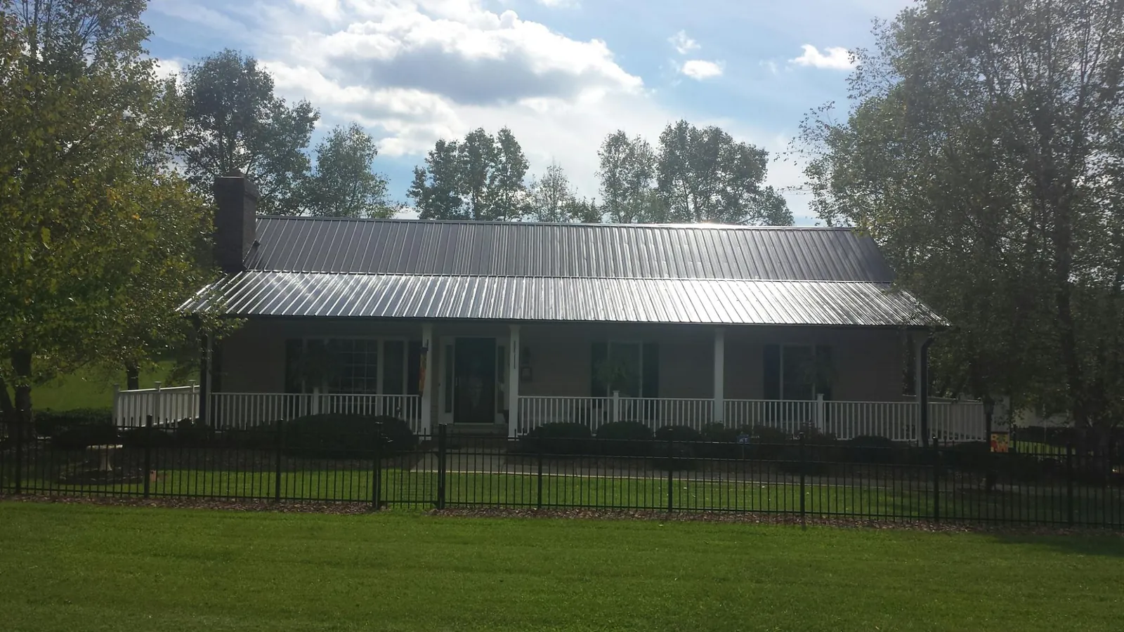 Gray metal roof on a brick ranch with a full width front porch — Gutter Guard Installation work by our crew in Eden Prairie